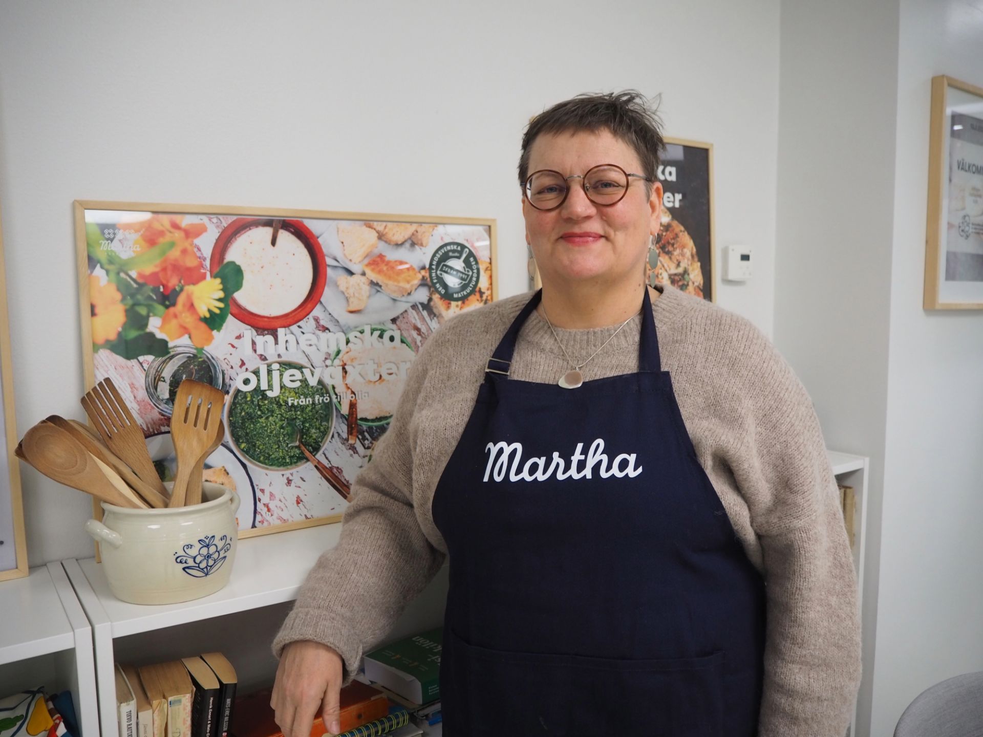 Camilla Komonen, verksamhetsledare för Marthaförbundet, poserar med ett Martha-förkläde på sig.