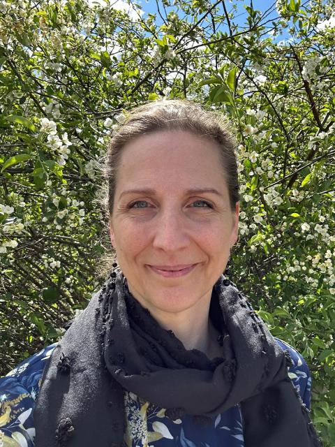 Marika Ehn framför en syrenbuske.
