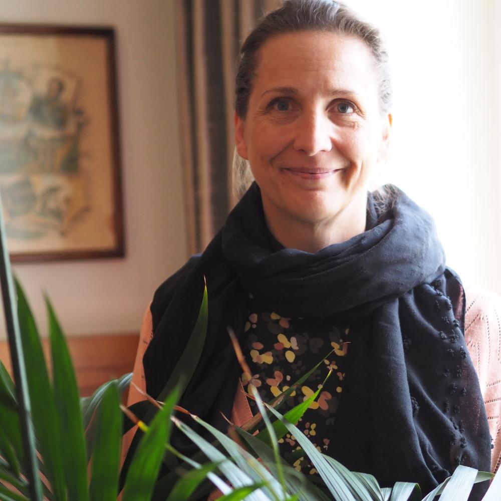 Marika Ehn poserar framför en grönväxt.